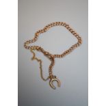 A 9ct rose gold curb link bracelet, with safety chain, suspending 9ct horseshoe charm 8.7g