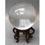 A carved crystal scrying ball on oriental hardwood stand. Note: By repute this item must NOT be