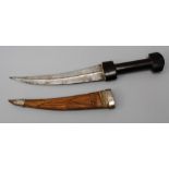 A late 19th century jambiya, the ebony handle over curved steel blade with raised medial ridge, in