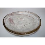 A studio art glass shallow dish with mauve swirled inclusions. 24.5 cms diameter.