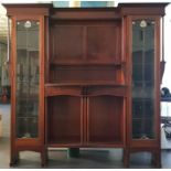 A Liberty & Co. Art Nouveau mahogany wall cabinet, c.1900, having shaped shelves and pillasters to