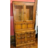 An Ercol design elm Bookcase on fall front bureau, two panel glazed doors, on a fall front bureau,