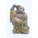 A Chinese part glazed pottery figure of Hotei, Republic period, modelled standing and holding a