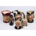 A collection of Royal Doulton character jugs including the Trapper, The Cardinal, Robin Hood,