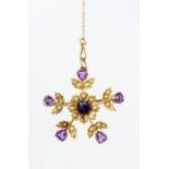 A Edwardian seed pearl and amethyst 9ct gold brooch, comprising a central round cut amethyst with