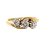 A three stone diamond 18ct gold cross over ring, comprising three claw set old cut diamonds with a