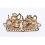 A Miniature white metal four piece tea service including tea and coffee pots, sugar bowl and cover