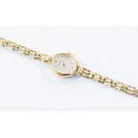 A 9ct gold ladies Accurist watch, oval silvered dial, gold tone baton markers and hands, case