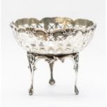 An Edwardian silver raised bon bon dish, wavy scroll border reticulated sides on three scroll ball