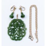 A carved nephrite jade pierced pendant with a 1c4t gold bale, on a plated chain along with a pair of