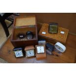 A collection of travel clocks, with a tea caddy and musical box