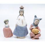 Three Nao figures of young girls, one with a pumpkin