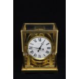 A Jaeger Le Coultre brass mantle clock, Atmos with white enamel dial and Roman numerals, the glass