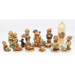 A collection of Hummel figures of children with Hummel candle