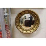 A late 19th Century fisheye wall mirror, in gilt wood, with cannonball surround