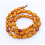 A butterscotch amber bead necklace, comprising graduated oval beads, from 10 x 7mm to 15 x 10mm,