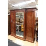 A Victorian triple sectioned mahogany wardrobe, mirrored door to middle, 224cm high, 210cm wide,