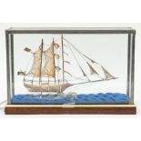 A filigree model of a two-masted ship, displayed in a perspex glazed wooden case, the case 27cm
