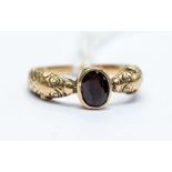 A Victorian 15ct gold and garnet set ring, the rub-over set oval garnet set to the centre of serpent