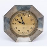An Art Deco silver mounted 8 day desk clock, inset with a brass clock, round cream dial with