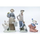 Two Nao figures of young boy with dog, boy dressed as clown and Lladro Dutch boy