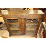 A 1970's oak glazed bookcase, Singer tredle sewing machine in oak work table, a mid 20th Century