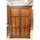 A 20th Century traditional oak two door wardrobe, in the Jacobean style, 88cm high, 125cm wide, 57cm