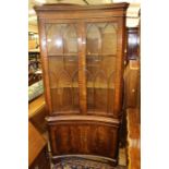 A Georgian style mahogany glazed corner cabinet, of concave form