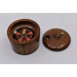 A treen roulette wheel box and cover, turned with a lid and string handle, 5cms high approx,