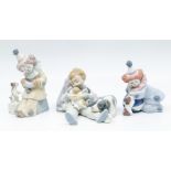 Three Lladro figures, two clowns and boy with puppies