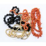 Two coral necklaces, two simulated pearl necklaces and a jet bead necklace