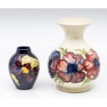 A Moorcroft posy vase in cream ground, with a dark blue Moorcroft small vase