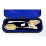 A cased set of two 18th Century silver parcel gilt berry spoons, repousse bird and filiate