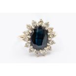 A 9ct gold sapphire and diamond cluster ring, the oval-cut natural sapphire approx 11.78mm x 8.