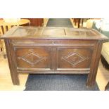 A 17th Century oak chest, panelled lid, two panelled front with carved lozenges, raised on stile