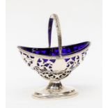 A Georgian style silver boat shaped sugar basket with swing handle, geometric openwork decoration on