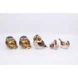 Five Royal Crown Derby paperweights including three owls, two gold stoppers and one silver