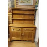 An Ercol elm dresser and rack, the rack with two plate shelves, the base section with two drawers