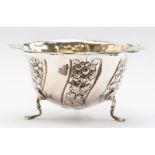 An Edwardian silver sugar bowl, wavy rim above body with wyvern fluted section chased with