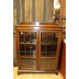 An Art Nouveau oak glazed bookcase, with stained glass to doors, 109cm high, 90cm wide, 27cm deep