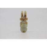 A Chinese pale celadon and russet jade amulet in the neolithic style, Qing Dynasty, of semi-