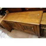 An early 20th Century oak sideboard, fitted with two carved doors, together with an oak side