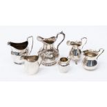 A collection of silver to include: George III bright cut engraved helmet shaped cream jug, London,