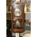 A George V oak eight day wall clock, silvered dial, glazed door with bevelled edge glass