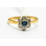An 18ct gold flower head diamond and sapphire dress ring, comprising a central round cut sapphire