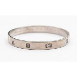 An Elizabeth II silver bangle of rectangular section, the outside with feature hallmarks,