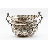 A Victorian silver small two handled porringer, griffin handles, wavy border, the body with wyvern