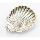 A late Victorian silver shell shaped butter dish, on three ball feet, by Josiah Williams & Co,