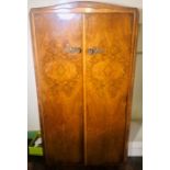 An Art Deco burr walnut ladies wardrobe, serpentine top above two panel doors with metal handles,