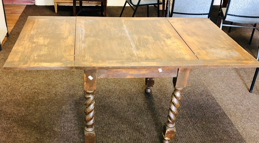 An early 20th Century oak folding leaf table, raised on twisted supports. 75cm H x 89cm D x 76cm